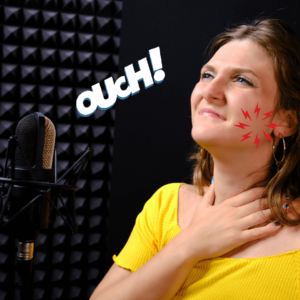 Singer in yellow top with microphone suffering from jaw pain.