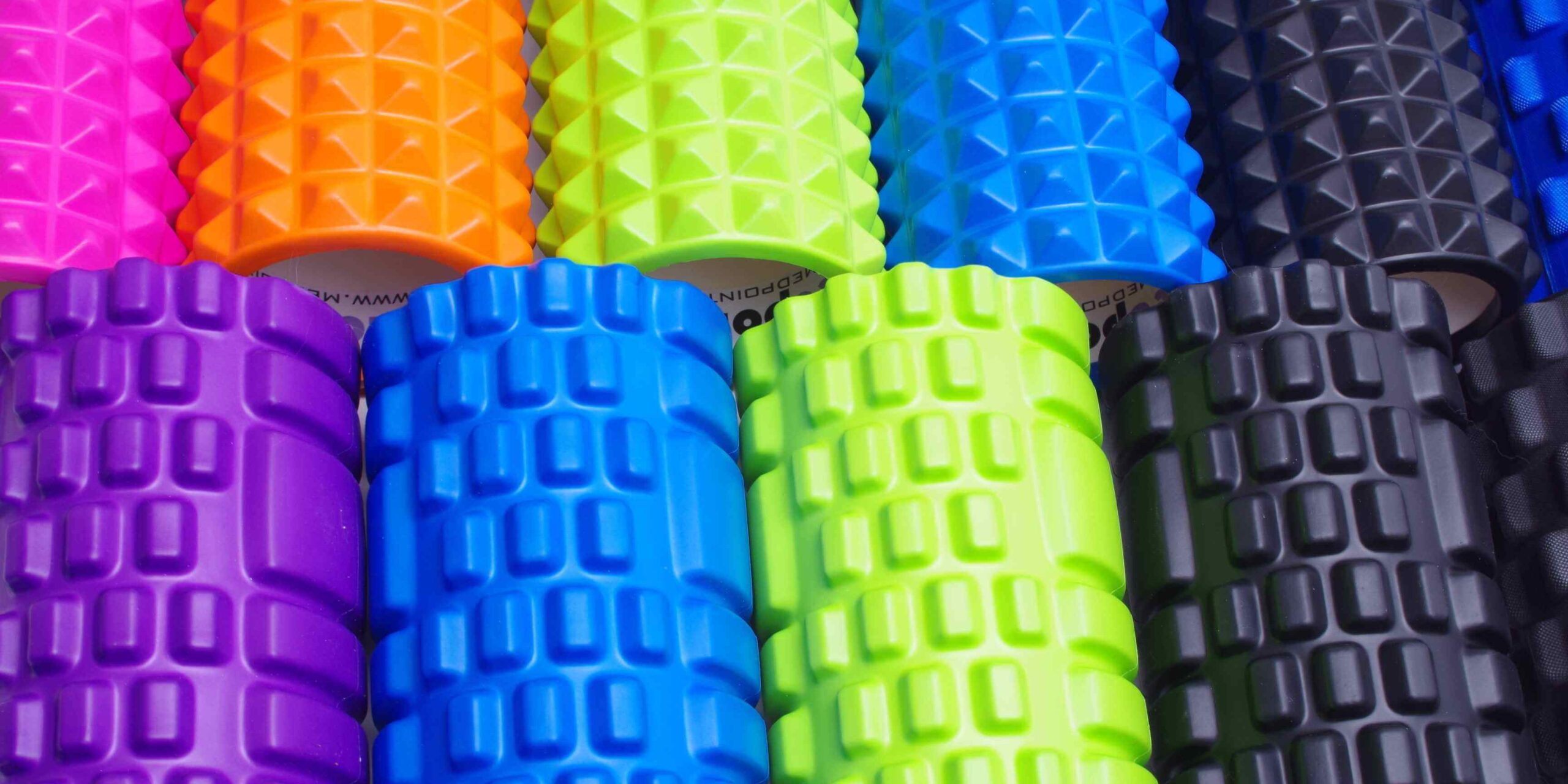 Many foam rollers of many colors all lined up