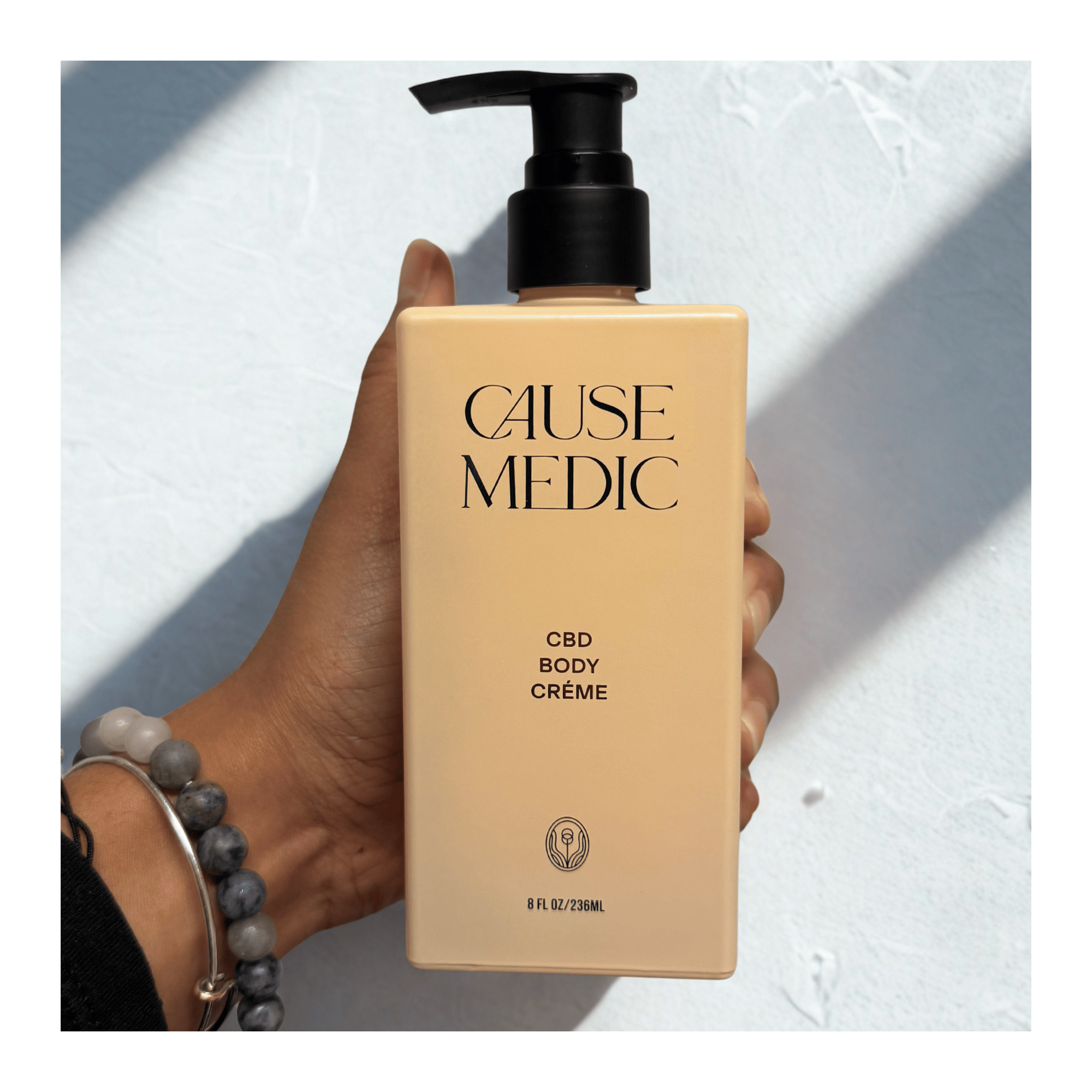 CBD massage cream bottle being held by a hand